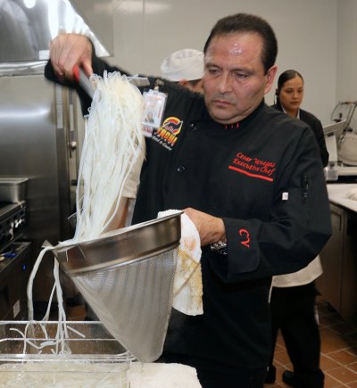 Sous Chef Cesar Venegas preparses a dish in the kitchen.